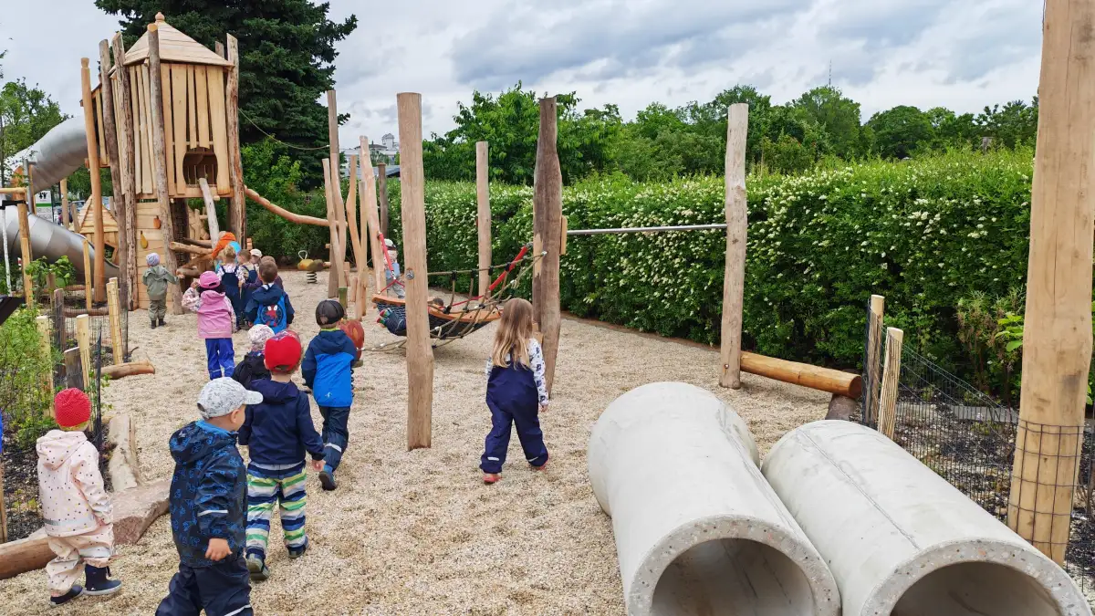 Kaum haben die Kinder das Eröffnungsband durchgeschnitten, stürmen sie den neuen Holzspielplatz am Frauensteiner Platz. Foto: Heiko Weckbrodt