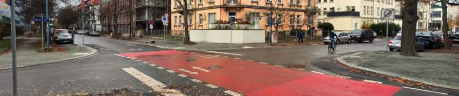 Arbeiter haben ab September 2025 die Kreuzung der Radroute Ost mit der Bärensteiner Straße verkleinert. Die vergrößerten Gehwege sind vorn, hinten links und rechts zu sehen. Am orangen Eckhaus wurden statt dessen Parkverbote eingerichtet. Foto: Heiko Weckbrodt